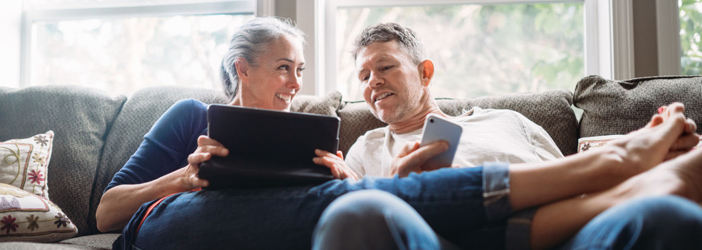 Property auction bidding by middle-aged-couple-on sofa - Bond Wolfe Auctions