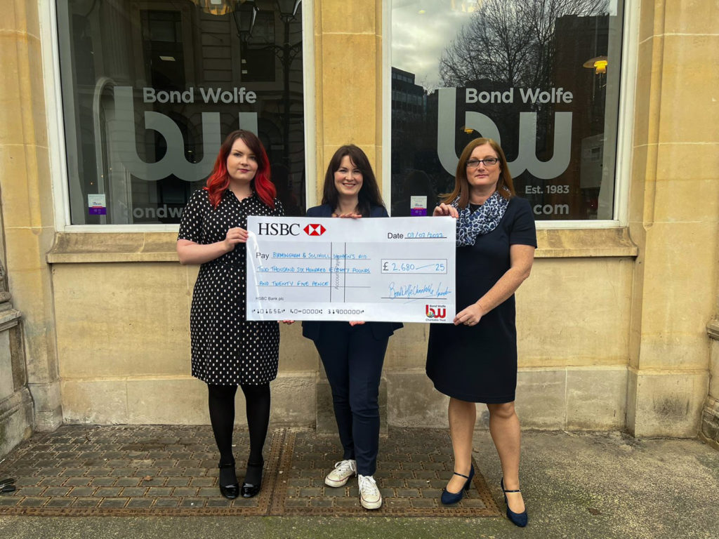 Bond Wolfe Charity image of three people holding a donated cheque