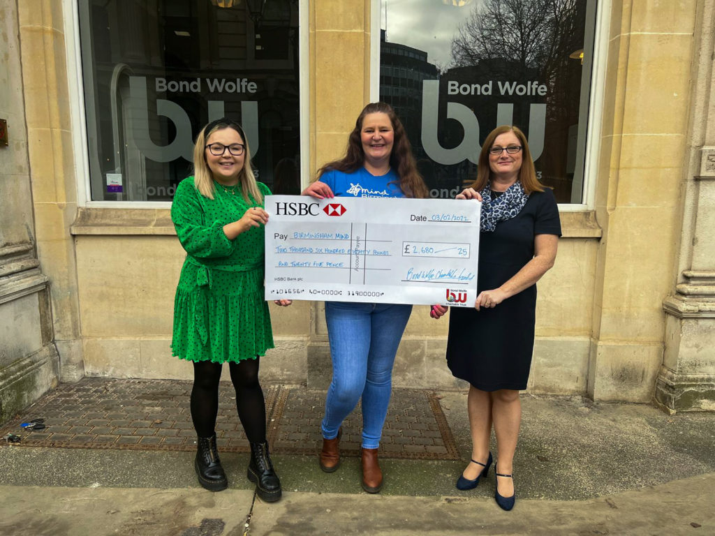 Bond Wolfe Charity image of three people holding a donated cheque