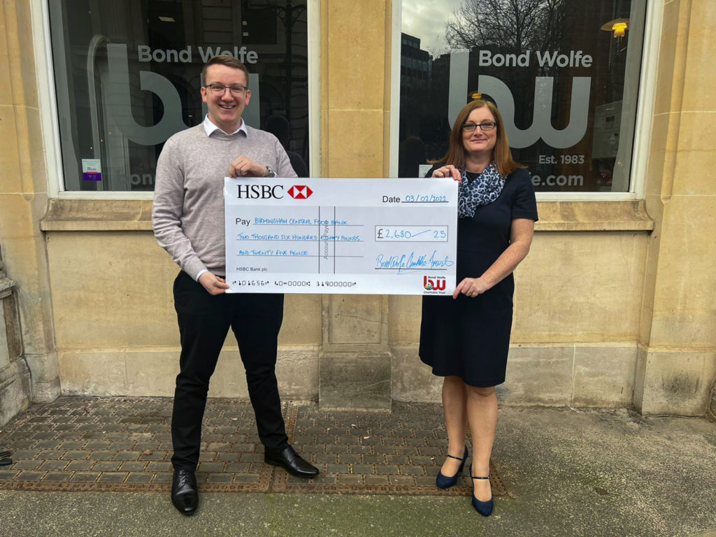 Bond Wolfe Charity image of two people holding a donated cheque